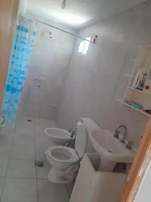 a white bathroom with a toilet and a sink at Sol y Calma in Villa Rumipal
