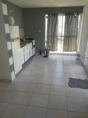 a kitchen with a refrigerator and a tile floor at Sol y Calma in Villa Rumipal
