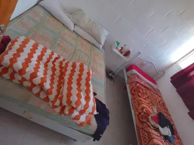 a bedroom with a bed with a orange and white comforter at Sol y Calma in Villa Rumipal