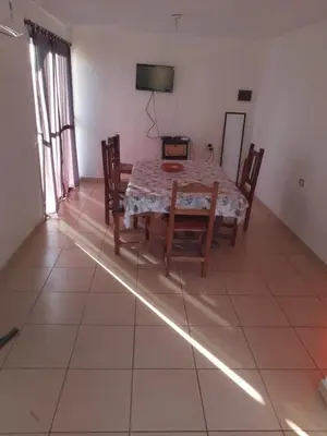 a dining room with a table and chairs and a television at Sol y Calma in Villa Rumipal