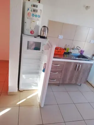 a small kitchen with a refrigerator with its door open at Sol y Calma in Villa Rumipal
