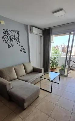 a living room with a couch and a glass table at Depto Moderno, Luminoso y Cerca de Todo Córdoba in Cordoba