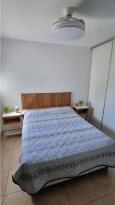 a bedroom with a bed with a blue comforter at Depto Moderno, Luminoso y Cerca de Todo Córdoba in Cordoba