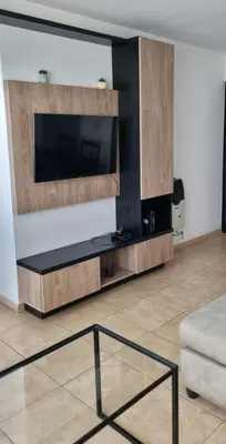 a living room with a tv and a glass table at Depto Moderno, Luminoso y Cerca de Todo Córdoba in Cordoba