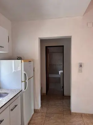 a kitchen with a white refrigerator and a bathroom at Complejo EbenEzer in Merlo