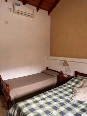 a bedroom with two beds and a air conditioner at Complejo EbenEzer in Merlo