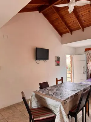 a dining room with a table and a tv on the wall at Complejo EbenEzer in Merlo