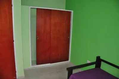 a bedroom with a mirror and a wooden door at Complejo Carola in Villa Carlos Paz