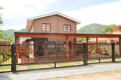 a house with a gate and a fence at Complejo Carola in Villa Carlos Paz