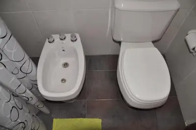 a bathroom with a toilet and a bidet and a sink at Complejo Carola in Villa Carlos Paz