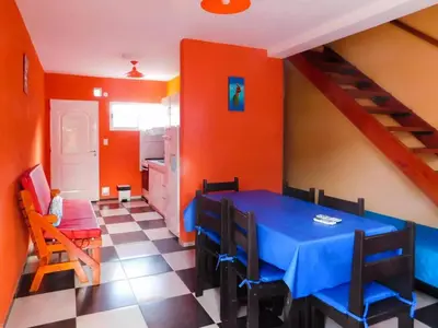 a dining room with a blue table and orange walls at Complejo Carola in Villa Carlos Paz