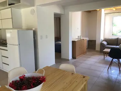 a kitchen and living room with a table and a refrigerator at Casa Titi in Arroyo de Los Patos