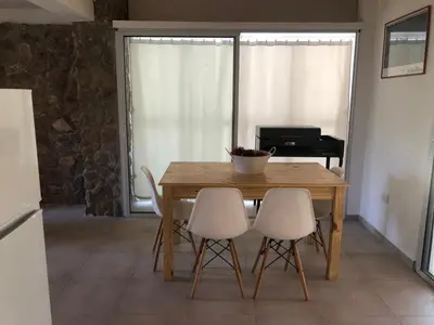 a dining room with a wooden table and chairs at Casa Titi in Arroyo de Los Patos