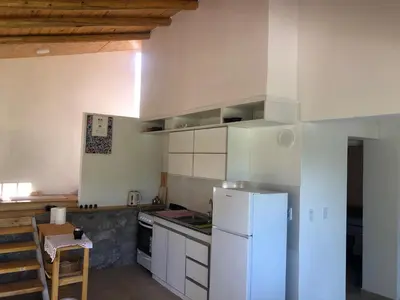 a kitchen with a white refrigerator and white cabinets at Casa Titi in Arroyo de Los Patos