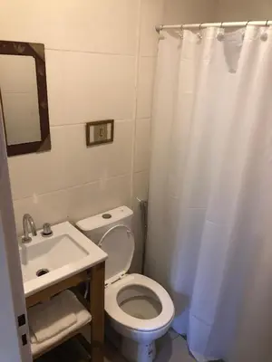 a bathroom with a white toilet and a sink at Casa Titi in Arroyo de Los Patos