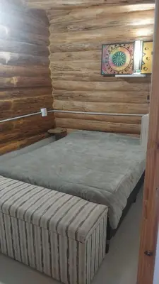 two twin beds in a room with wooden walls at Exclusiva cabaña in Villa Santa Cruz del Lago