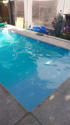 a swimming pool with blue water in a house at Exclusiva cabaña in Villa Santa Cruz del Lago