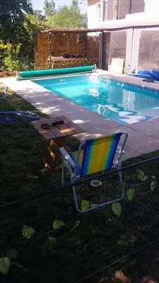 a lounge chair sitting next to a swimming pool at Exclusiva cabaña in Villa Santa Cruz del Lago
