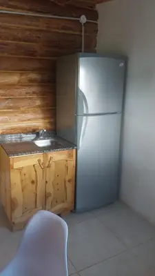 a white refrigerator in a kitchen with a sink at Exclusiva cabaña in Villa Santa Cruz del Lago