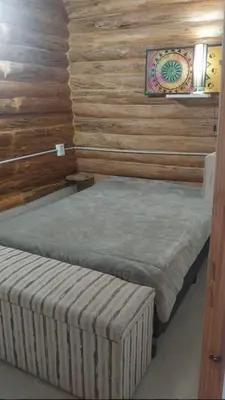 two twin beds in a room with wooden walls at Exclusiva cabaña in Villa Santa Cruz del Lago