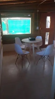 a table and chairs in a room with a window at Exclusiva cabaña in Villa Santa Cruz del Lago