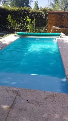 a swimming pool with blue water in a yard at Exclusiva cabaña in Villa Santa Cruz del Lago