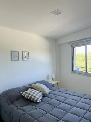 a bedroom with a blue bed with a window at Departamento en General Paz I in Cordoba