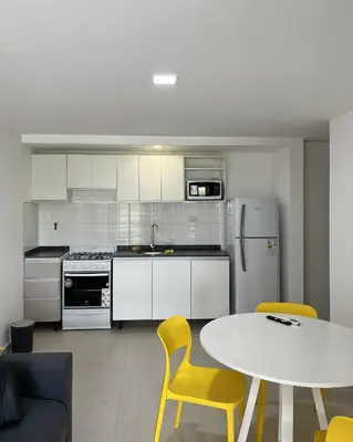 a kitchen with a table and yellow chairs at Departamento en General Paz I in Cordoba