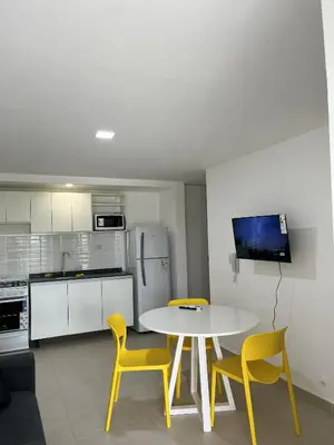 a kitchen with a table and two yellow chairs at Departamento en General Paz I in Cordoba