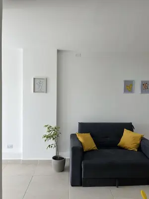a black couch with yellow pillows in a living room at Departamento en General Paz I in Cordoba