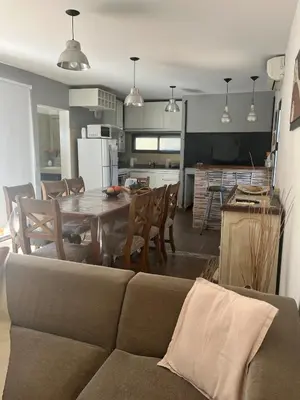 a living room and kitchen with a couch and a table at Rincón Villa del Lago in Villa Carlos Paz