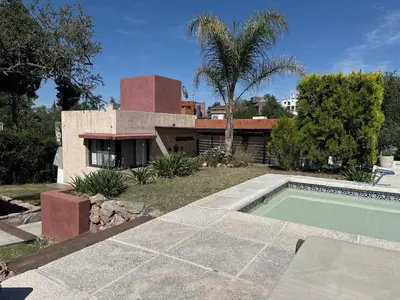 a house with a swimming pool in front of a house at Rincón Villa del Lago in Villa Carlos Paz