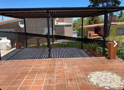 a pavilion with a brick patio at Rincón Villa del Lago in Villa Carlos Paz