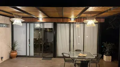 a dining room with a glass table and chairs at Rincón Villa del Lago in Villa Carlos Paz