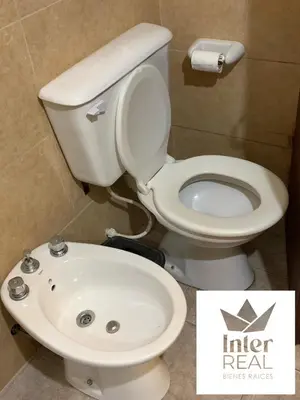 a bathroom with a white toilet and a sink at cabañas Gerom in Merlo