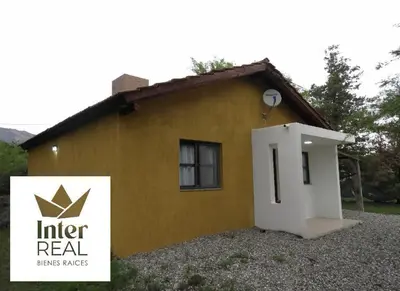 a small yellow house with a door in front of it at cabañas Gerom in Merlo