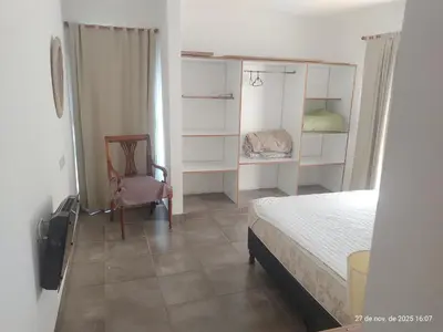 a small bedroom with a bed and a chair at Cuesta Blanca dos dormitorios cochera in Cuesta Blanca