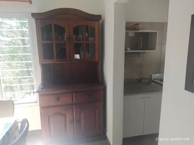 a wooden cabinet in a kitchen next to a window at Cuesta Blanca dos dormitorios cochera in Cuesta Blanca