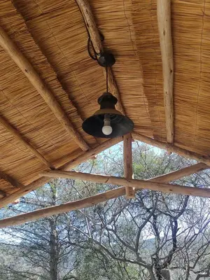 a black light hanging from the ceiling of a wooden roof at Cuesta Blanca dos dormitorios cochera in Cuesta Blanca