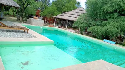 a large blue swimming pool with a bench next to it at cabañas Gerom in Merlo