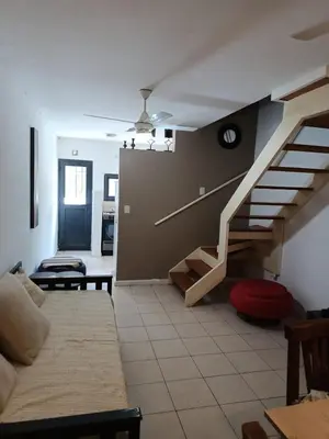 a living room with a staircase and a couch at Complejo NOVIEMBRE in Cordoba