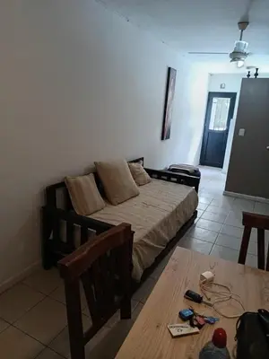 a bedroom with a bed and a table in a room at Complejo NOVIEMBRE in Cordoba