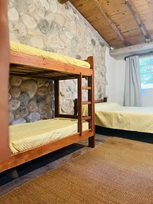 two bunk beds in a room with a stone wall at Cosmoqui Casa Boutique in Villa de Las Rosas