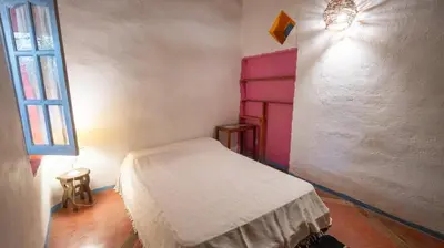 a small room with a bed and a window at Cosmoqui Casa Boutique in Villa de Las Rosas