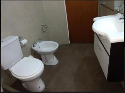 a bathroom with a toilet and a sink at Casa con vista a las Sierras y pileta privada in San Antonio de Arredondo