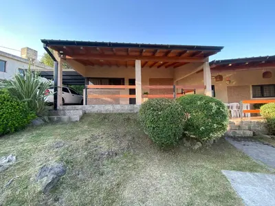 a house with a car parked in front of it at Casa con vista a las Sierras y pileta privada in San Antonio de Arredondo