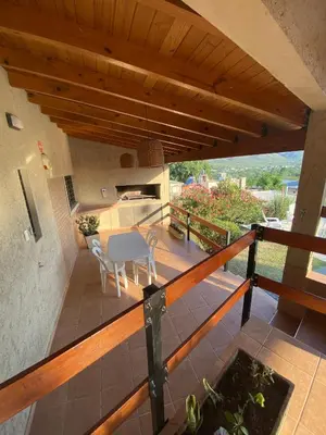 a balcony of a house with a table and chairs at Casa con vista a las Sierras y pileta privada in San Antonio de Arredondo