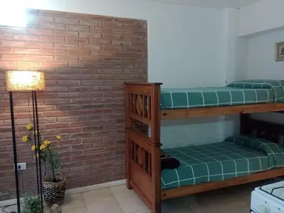 two bunk beds in a room with a brick wall at Cabañas Sprinter in Trapiche