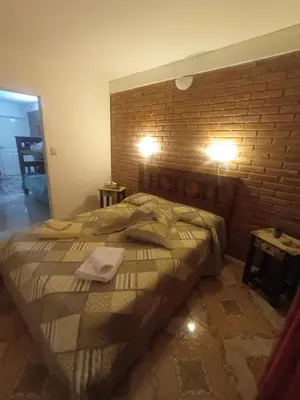 a large bed in a room with a brick wall at Cabañas Sprinter in Trapiche