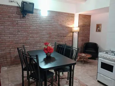 a table and chairs with a vase of flowers on it at Cabañas Sprinter in Trapiche